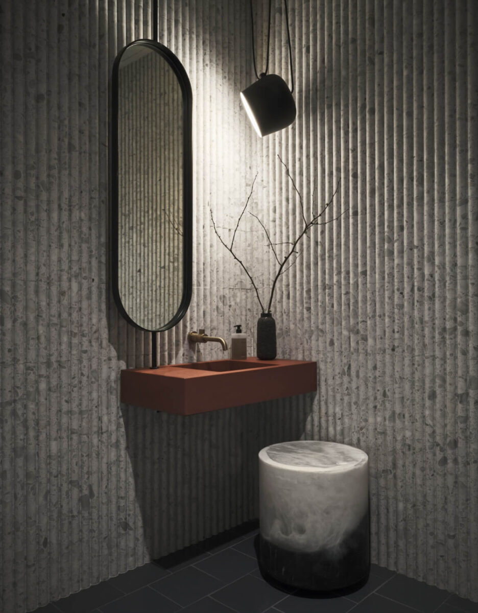 concrete fluted wall covering and minimalist sink and mirror at Sassetta